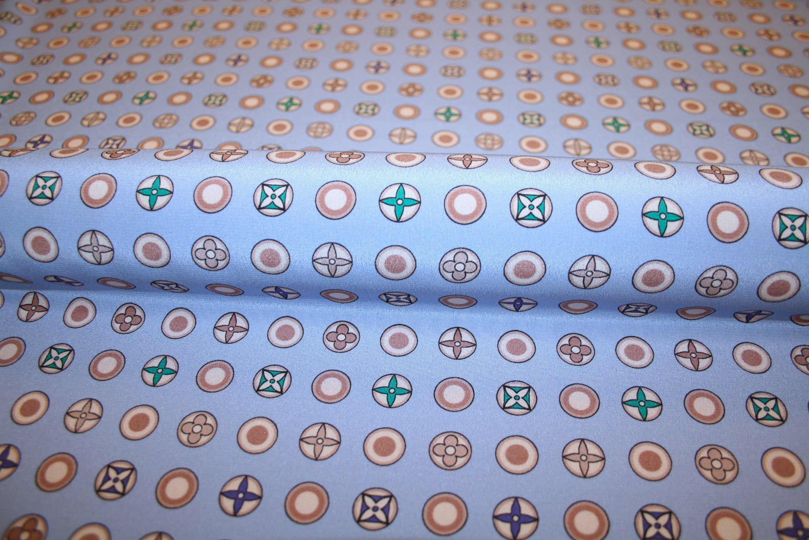 Silke crepe de chine stof med logoprint på lavendel bund